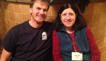 A man and a woman wearing a name badge smiling side by side at the 2014 NWRA symposium.