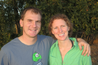 The two WRMD founders smiling outdoors against trees at golden hour, one in a WRMD worm logo T-shirt.