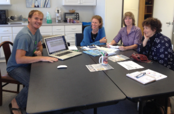 A WRMD team member shows the database on a laptop to three wildlife center staff seated around an office table.