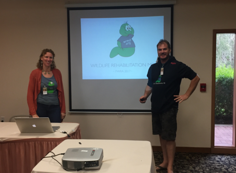 Two WRMD presenters beside a projection screen showing the WRMD mascot and a Wildlife Rehabilitation MD FWRA 2017 slide.