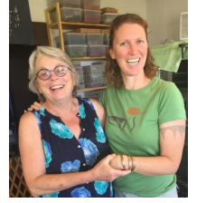 Two women smile arm in arm in a storeroom during the visits to New Mexico wildlife organizations.