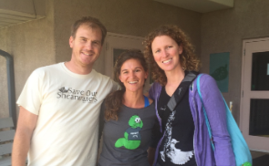 Three smiling people pose together outdoors, one wearing a Save Our Shearwaters T-shirt.